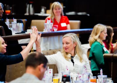 Two women high fiving at The Common Ground of Energy Transformation event